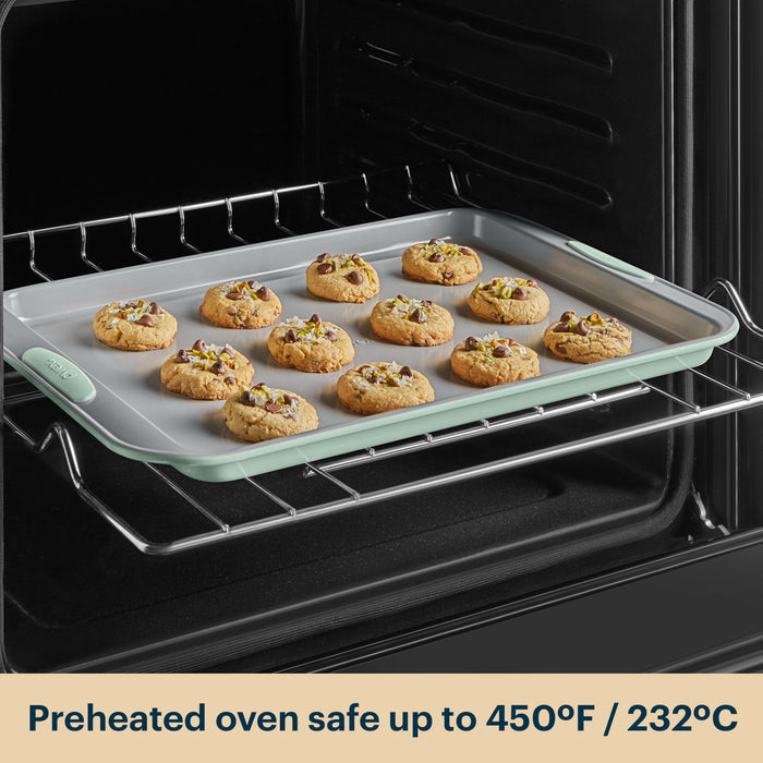 Cookies baking on a silicone baking mat inside an oven with text indicating safe temperature.