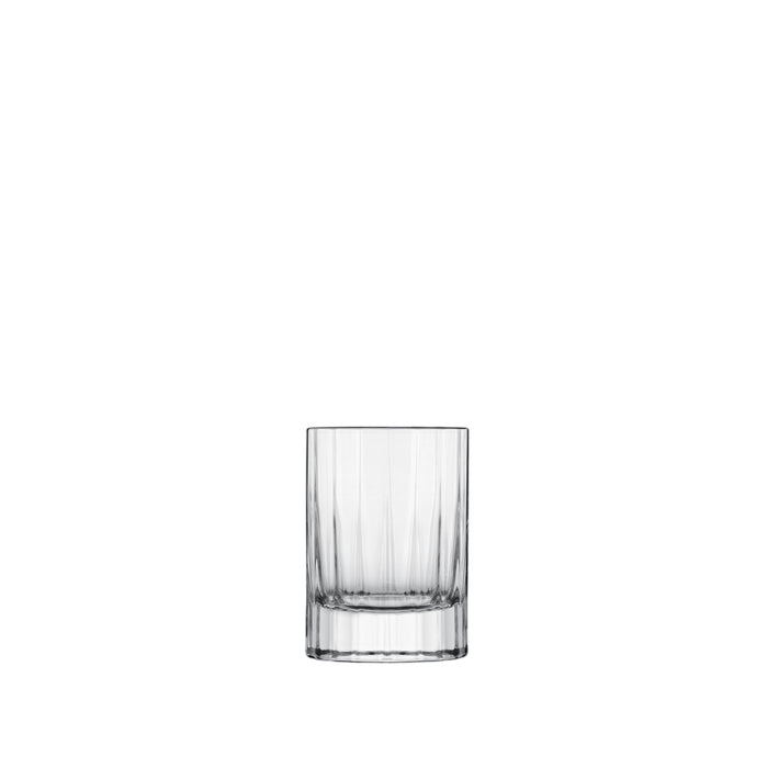 A clear, faceted, round, retro-style Bach shot glass with a thick base.
