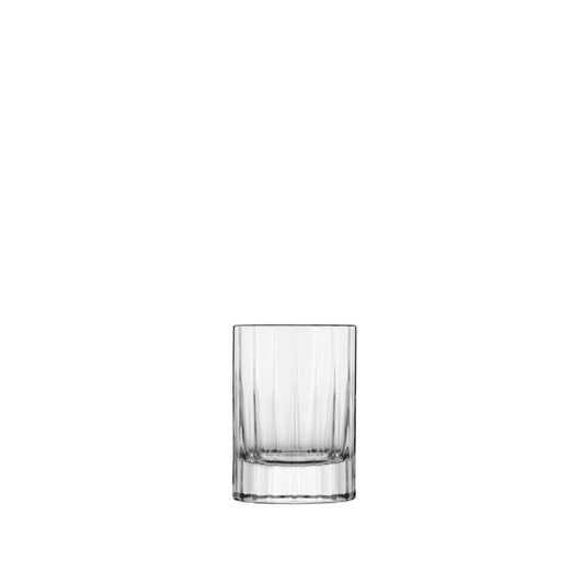 A clear, faceted, round, retro-style Bach shot glass with a thick base.