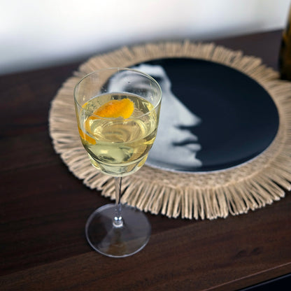 Barracuda glass with non-alcoholic cocktail garnished with a lemon twist on a wooden table