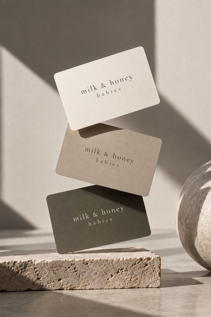 milk & honey babies gift cards in cream, stone and olive, on travertine