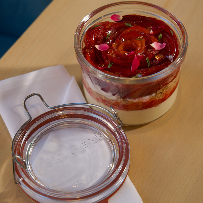 Glass jar with layered dessert on a wooden table