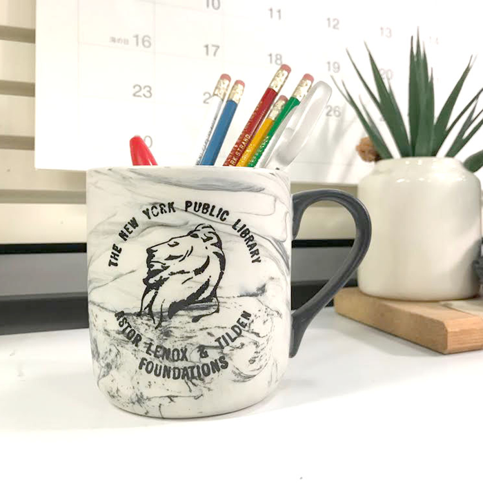 White marbleized mug with vintage NYPL lion logo in black as a pencil holder.