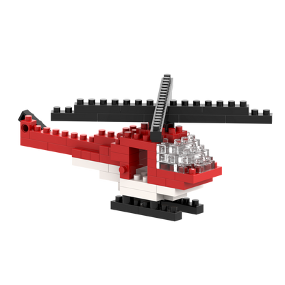 The Brixies Postcard Helicopter is a mini build kit made from red, white, and black micro bricks, with a large black rotor and clear cockpit. Ideal for collectors or as a unique postcard gift. Set against a plain white background.