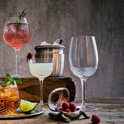 Assorted Roma 1960 cocktails in various glasses on a wooden table with a dark background