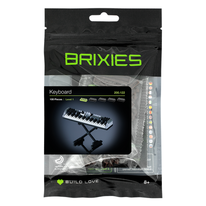 The Brixies Small Zip Bag Keyboard is a micro-brick kit with 100 pieces for ages 8+, featuring a 3D piano keyboard model in sleek black packaging and includes a reusable zip storage bag for easy organization.