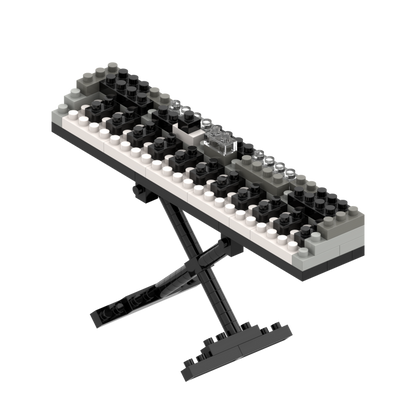 The Brixies Small Zip Bag Keyboard is a micro-brick 3D piano keyboard model with realistic black, white, and gray keys on an X-shaped stand. It comes in a reusable zip storage bag for convenient organization.