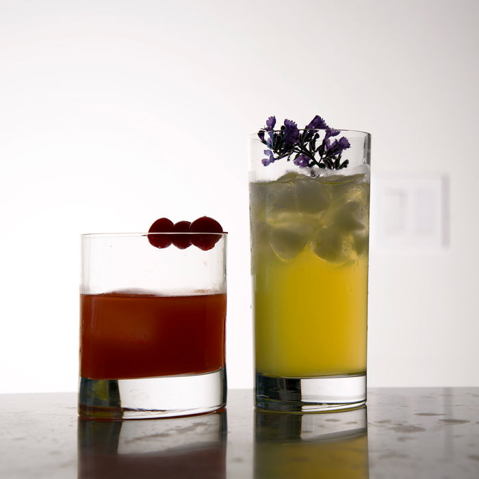 Veronese DOF and Highball Glasses filled with garnished cocktails standing on a light background